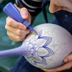 Rhian Malin decorating a mandala bottle in her workshop 2019